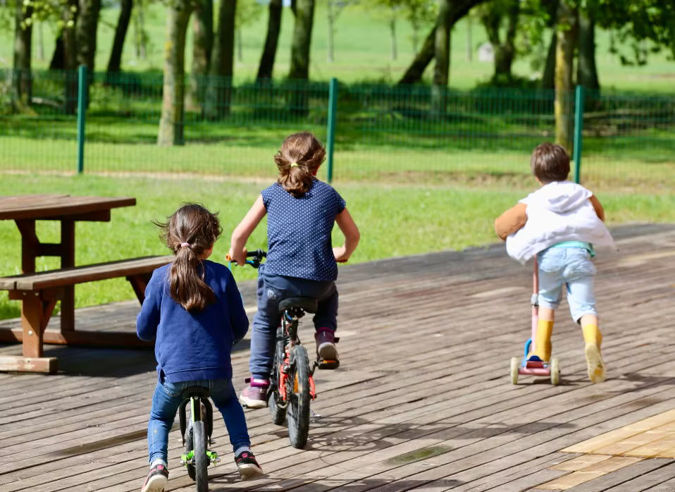 Des enfants jouent en faisant du vélo