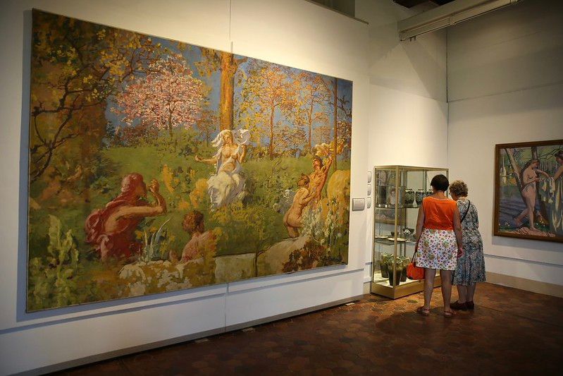 Visiteurs contemplant des œuvres dans un des pièces du musée Maurice Denis.
